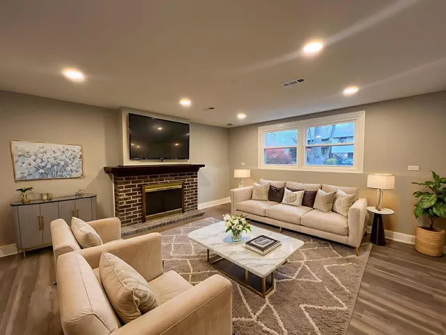 a living room with computer on a desk and bookshelf