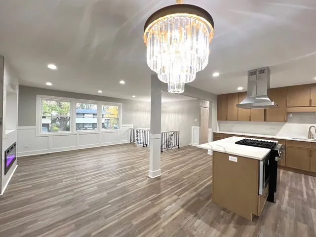 a kitchen with stove and wooden floor