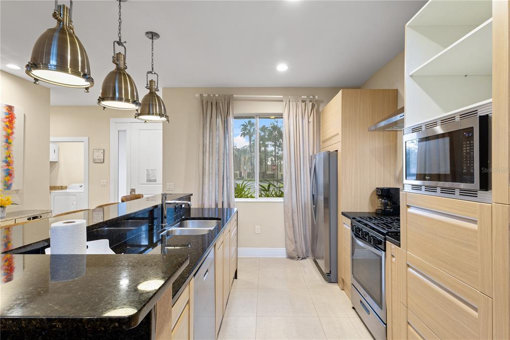 7657 Amazonas Street Kissimmee, FL 34747 - Photo 11 of 53 a kitchen with kitchen island granite countertop a sink stainless steel appliances and cabinets