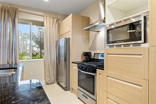 a kitchen with stainless steel appliances kitchen island granite countertop a table and chairs in it