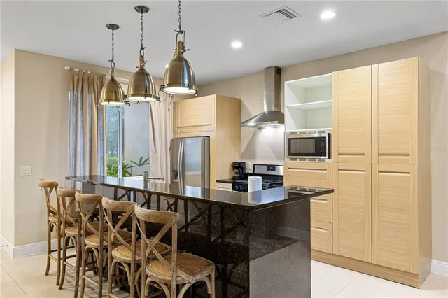 a kitchen with a table chairs refrigerator and microwave