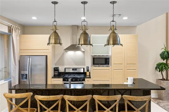 a kitchen with stainless steel appliances a stove a sink and a refrigerator