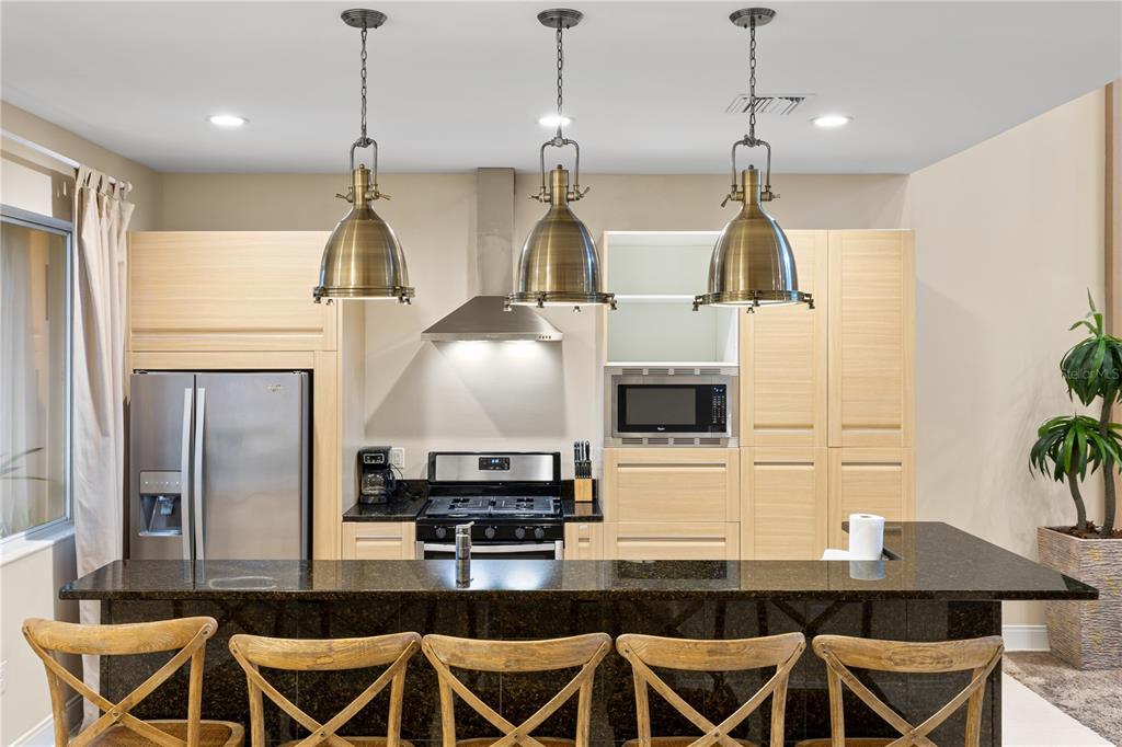 7657 Amazonas Street Kissimmee, FL 34747 - Photo 14 of 53 a kitchen with a table chairs refrigerator and microwave