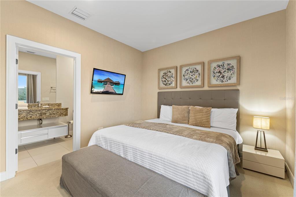 7657 Amazonas Street Kissimmee, FL 34747 - Photo 46 of 53 a bedroom with a large bed and a view of bathroom