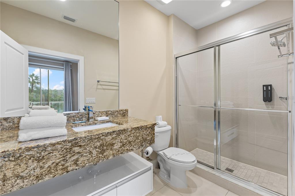 7657 Amazonas Street Kissimmee, FL 34747 - Photo 47 of 53 a bathroom with a granite countertop sink toilet and shower