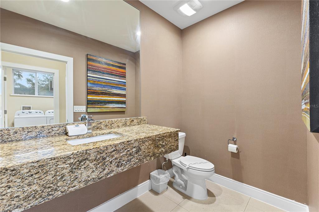 7657 Amazonas Street Kissimmee, FL 34747 - Photo 7 of 53 a bathroom with a granite countertop sink a toilet and a window