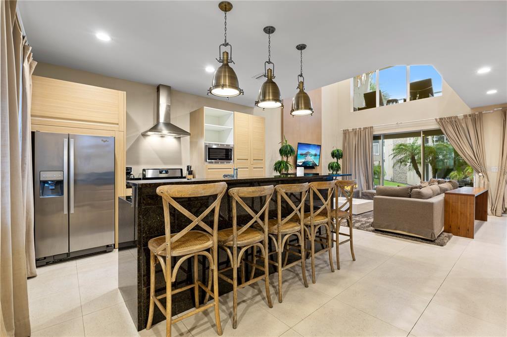 7657 Amazonas Street Kissimmee, FL 34747 - Photo 8 of 53 a kitchen with stainless steel appliances kitchen island granite countertop a stove a sink and a refrigerator