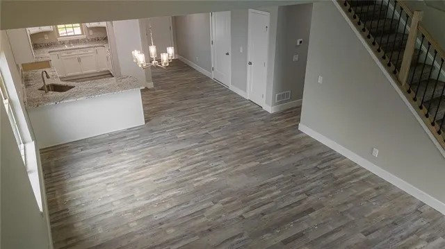 a kitchen with granite countertop wooden floor and electronic appliances