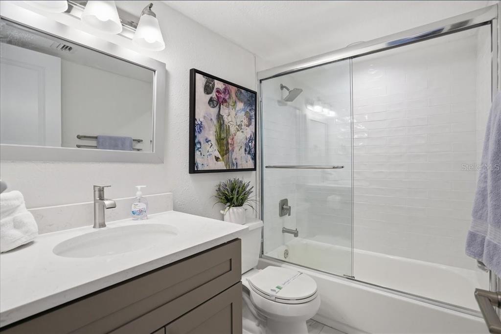 8911 Blind Pass Road, Unit 118 St. Pete Beach, FL 33706 - Photo 29 of 34 a bathroom with a sink toilet and shower