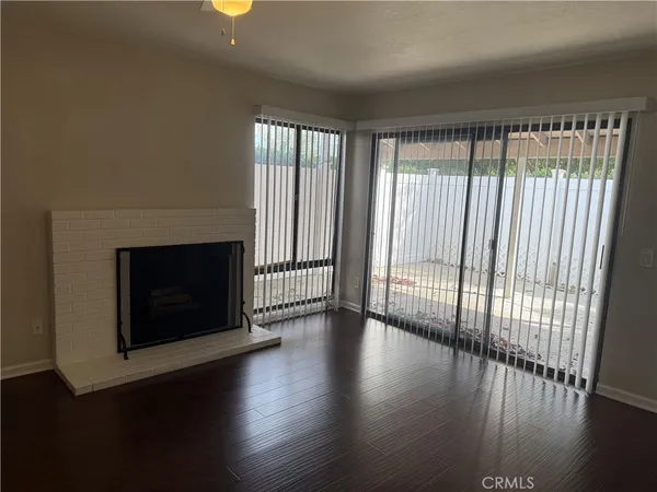a view of a livingroom with wooden floor and a fireplace