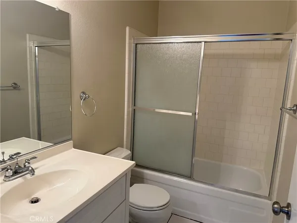 a bathroom with a granite countertop shower and a toilet