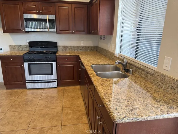 a kitchen with granite countertop a sink and a stove