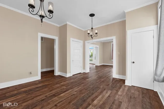 a view of an empty room with wooden floor fridge and a window