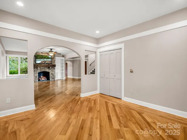 a view of empty room with fireplace and wooden floor