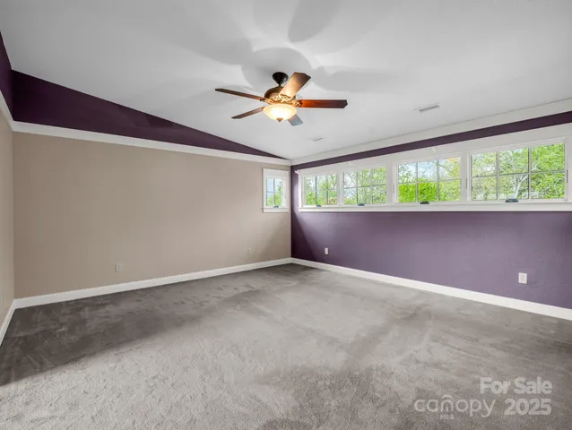 an empty room with a window and a ceiling fan