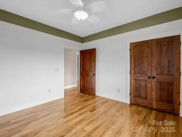 a view of an empty room with wooden floor
