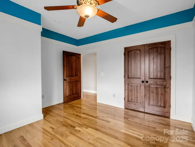 a view of an empty room with wooden floor