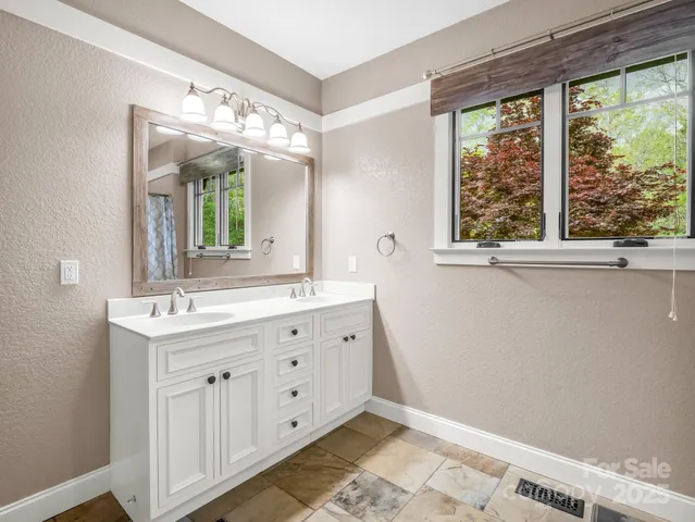 a bathroom with a double vanity sink and a mirror