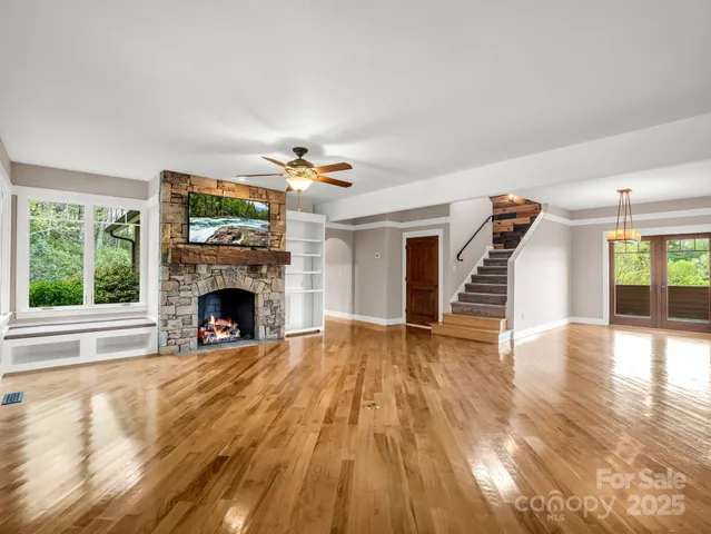 a view of empty room with wooden floor and fireplace