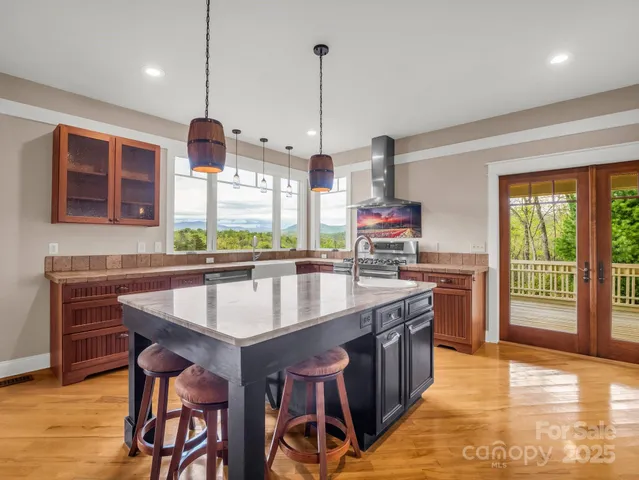 a kitchen with a stove a counter top space and wooden floor