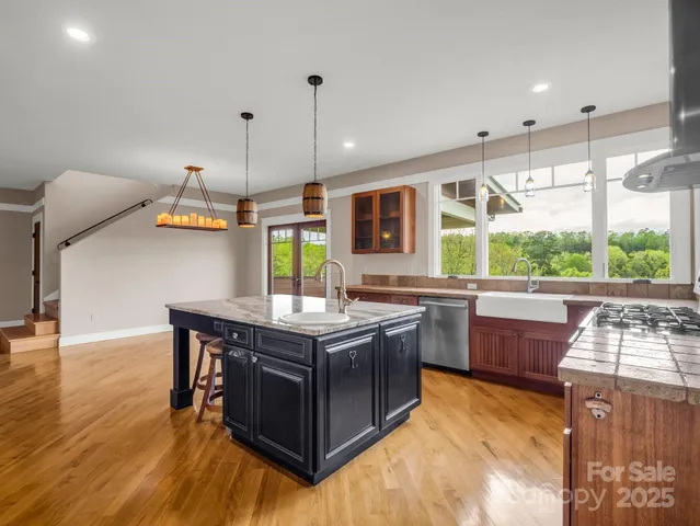 a kitchen with stainless steel appliances granite countertop a stove and a wooden floors