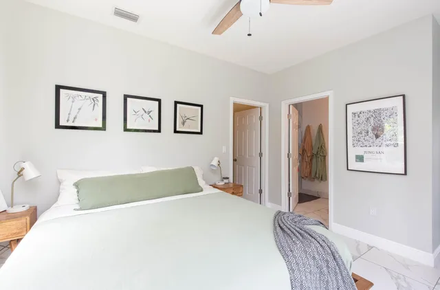 a bedroom with a bed and painting on the wall