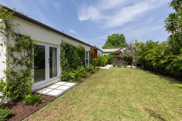 a backyard of a house with plants and outdoor seating