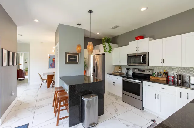 a kitchen with stainless steel appliances a stove refrigerator sink and microwave