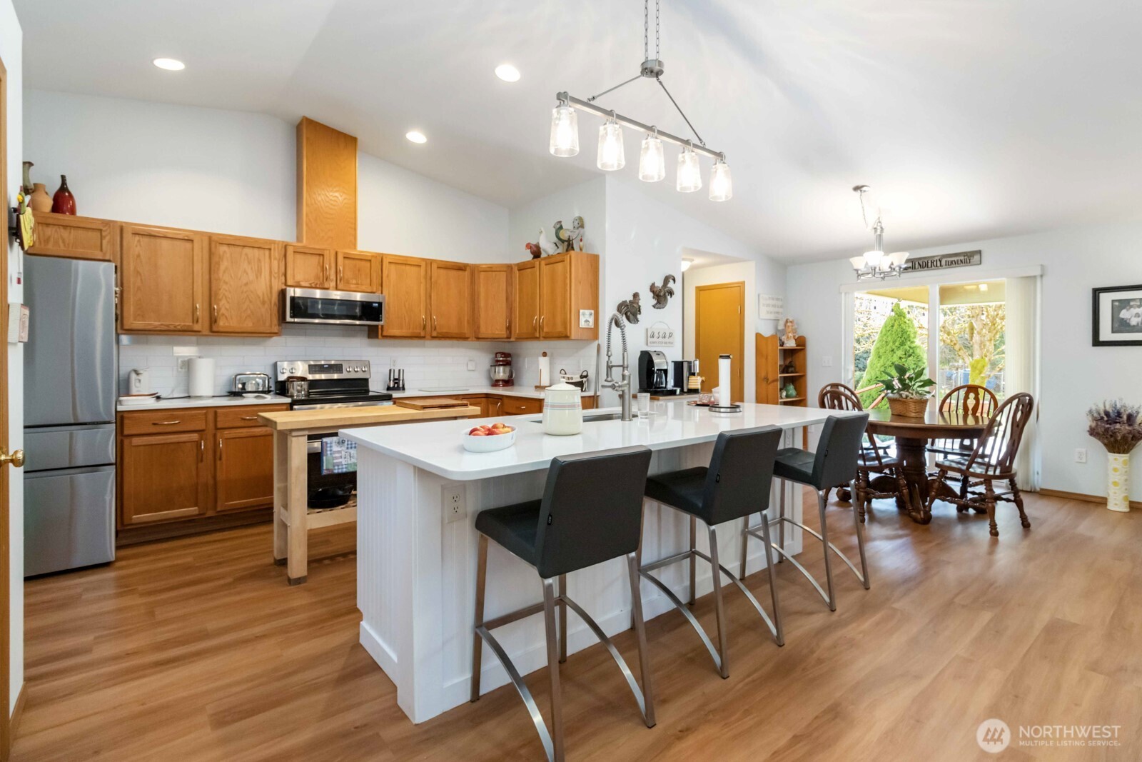 413 Haywire Road Winlock, WA 98596 - Photo 22 of 40 a kitchen with stainless steel appliances kitchen island granite countertop a table chairs and a refrigerator