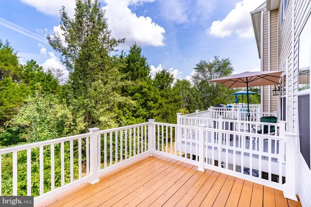 a view of a wooden deck and a yard with swimming pool