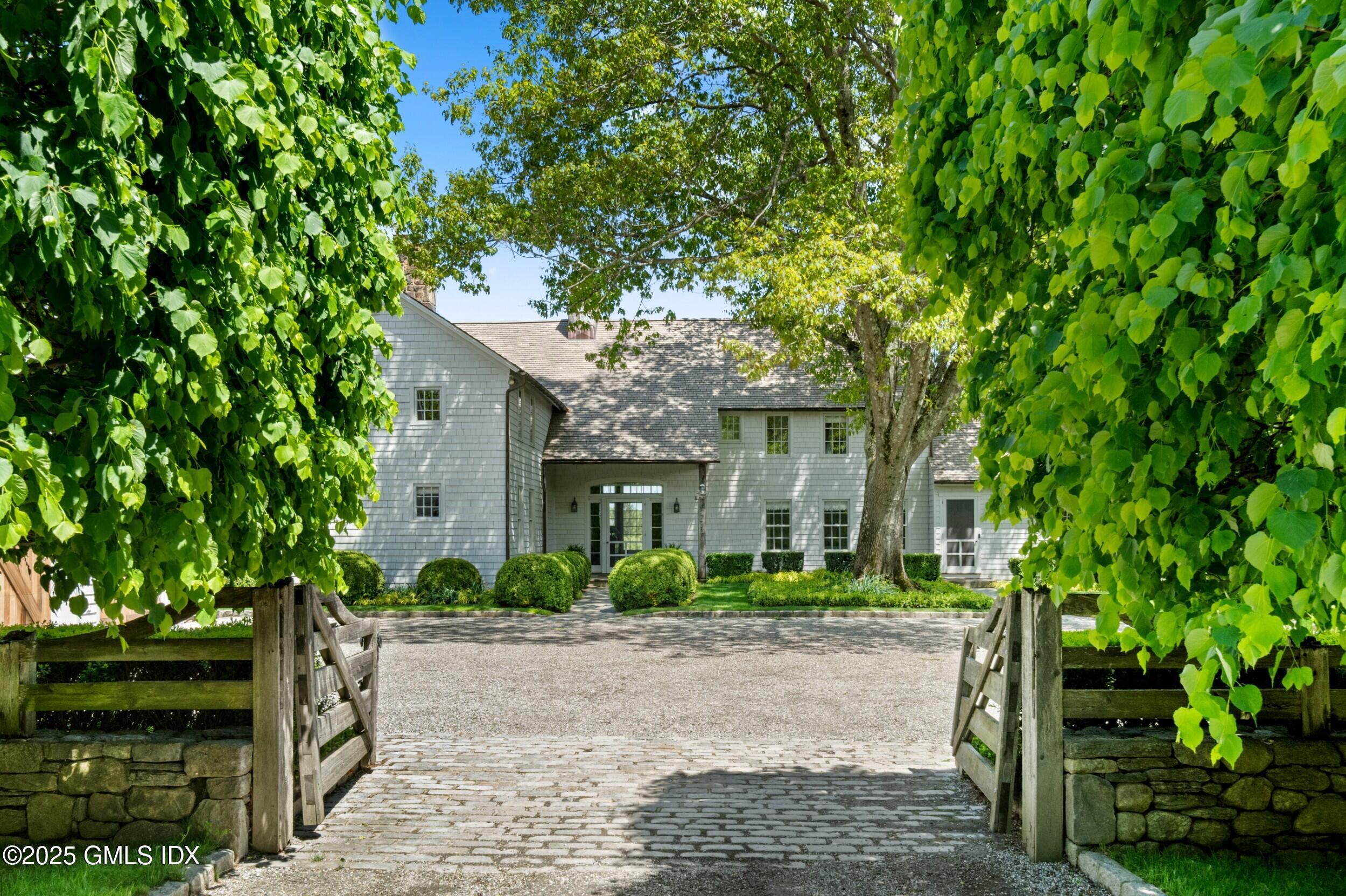 945 Oenoke Ridge New Canaan, CT 06840 - Photo 15 of 94 a front view of a house with a garden