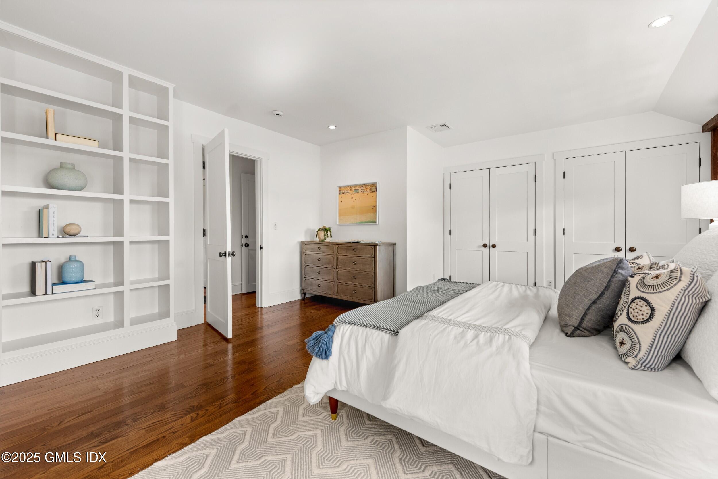 945 Oenoke Ridge New Canaan, CT 06840 - Photo 49 of 94 a bedroom with a bed and a book shelf