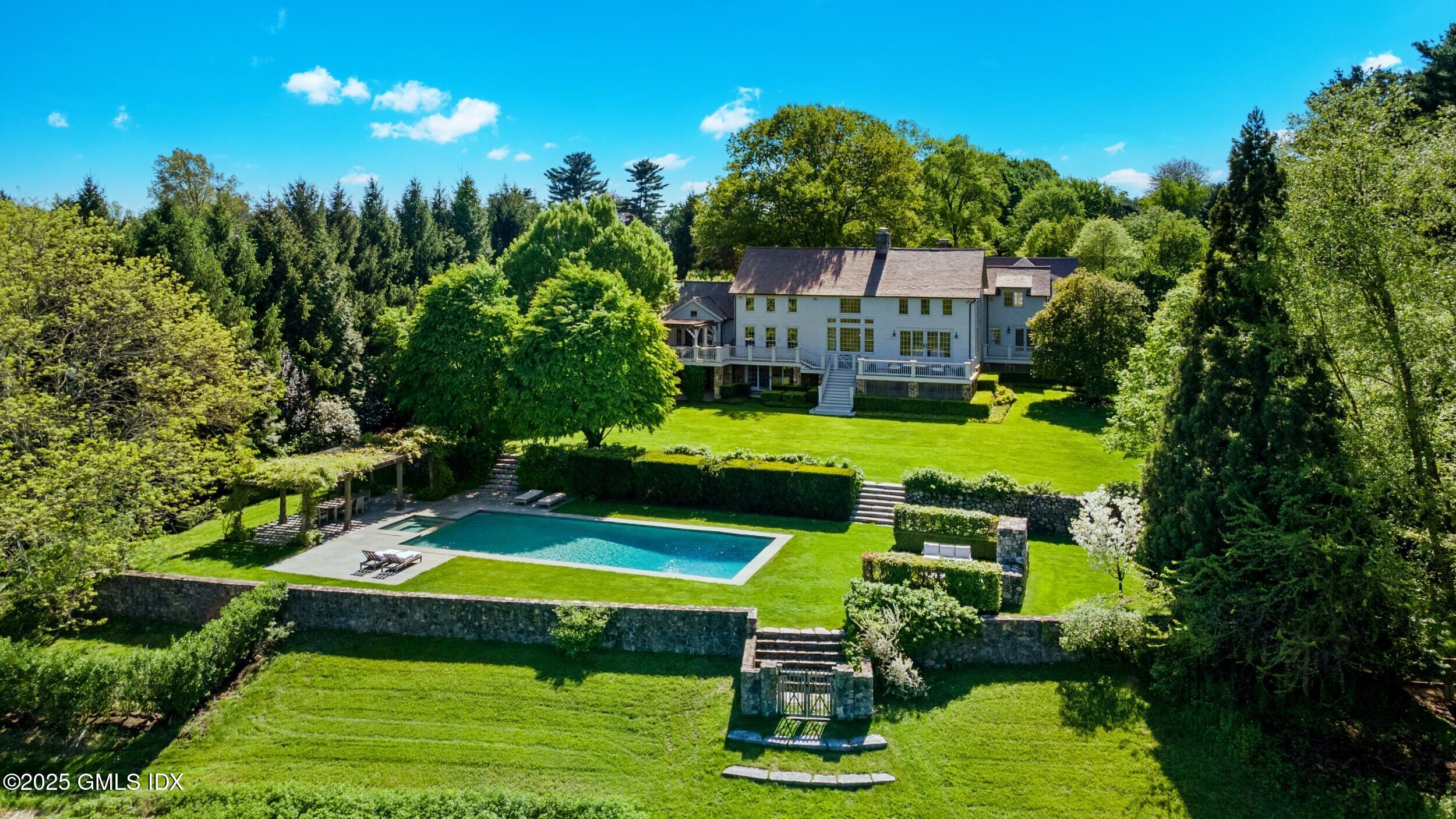 945 Oenoke Ridge New Canaan, CT 06840 - Photo 6 of 94 a swimming pool with outdoor seating and yard