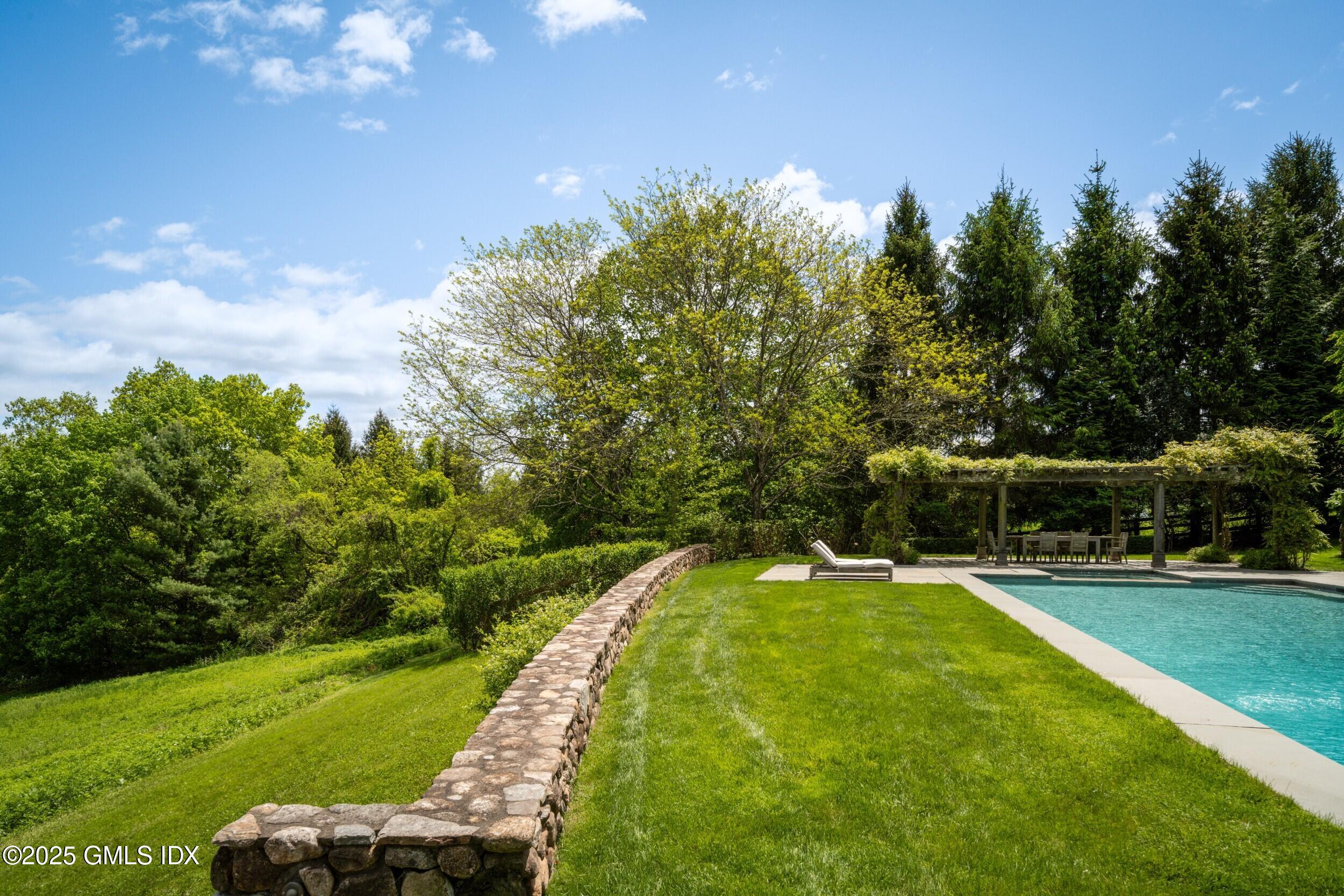 945 Oenoke Ridge New Canaan, CT 06840 - Photo 77 of 94 a view of a swimming pool with a garden