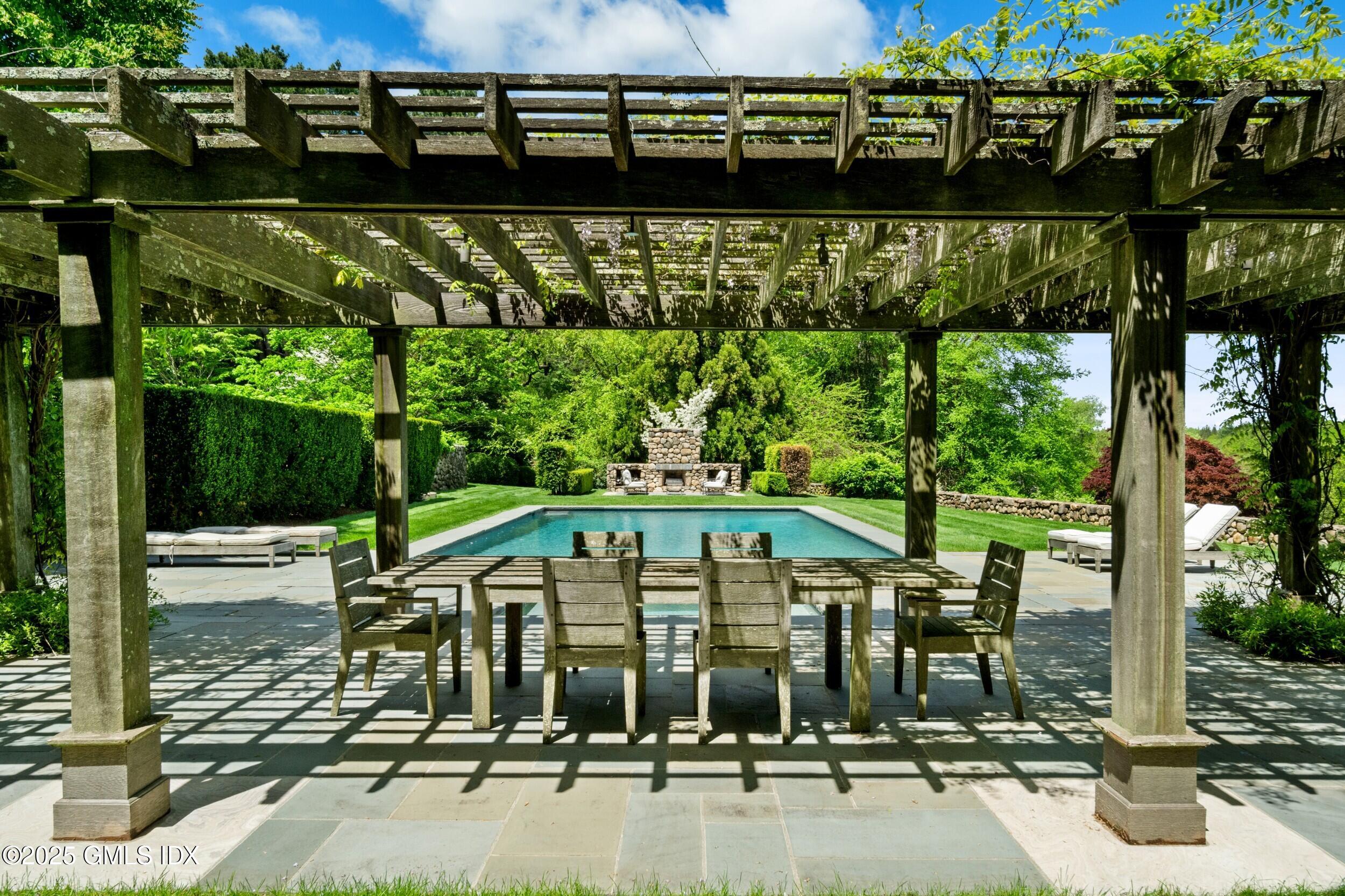 945 Oenoke Ridge New Canaan, CT 06840 - Photo 8 of 94 a view of a swimming pool with a patio