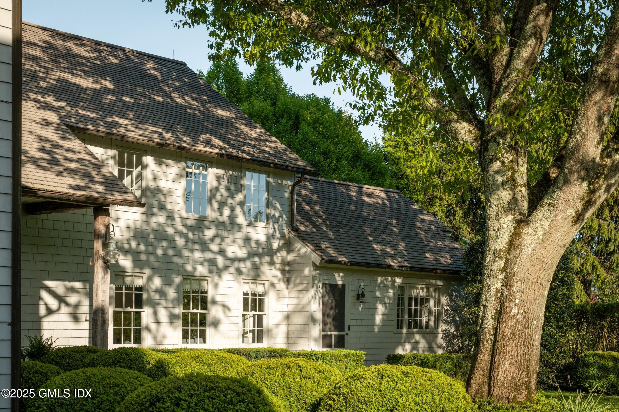 945 Oenoke Ridge New Canaan, CT 06840 - Photo 85 of 94 front view of a house with a garden