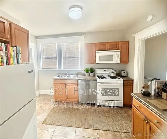 a kitchen with granite countertop white cabinets and white appliances