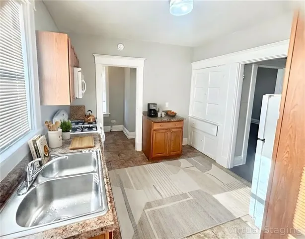 a kitchen with stainless steel appliances granite countertop a sink and a refrigerator