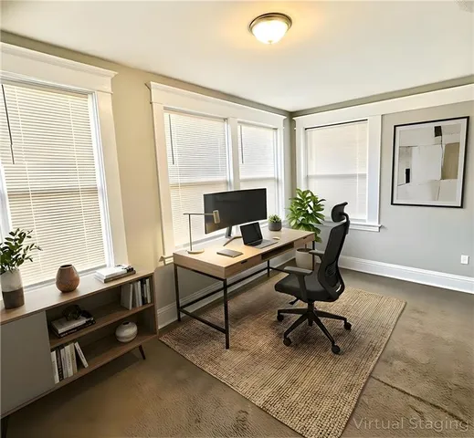 a view of a workspace with furniture and a window