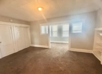 an empty room with windows and closet