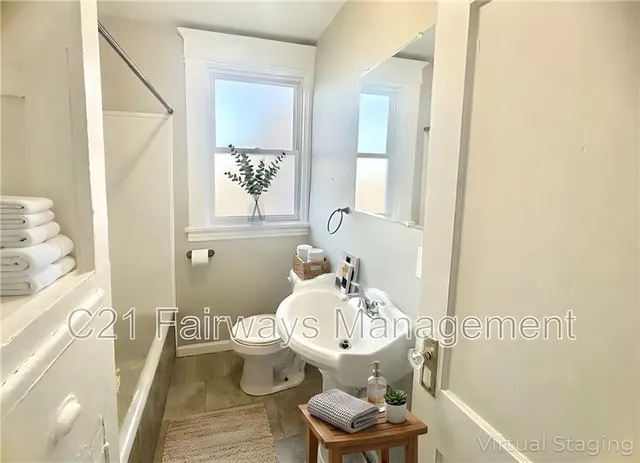a bathroom with a sink and mirror with toilet