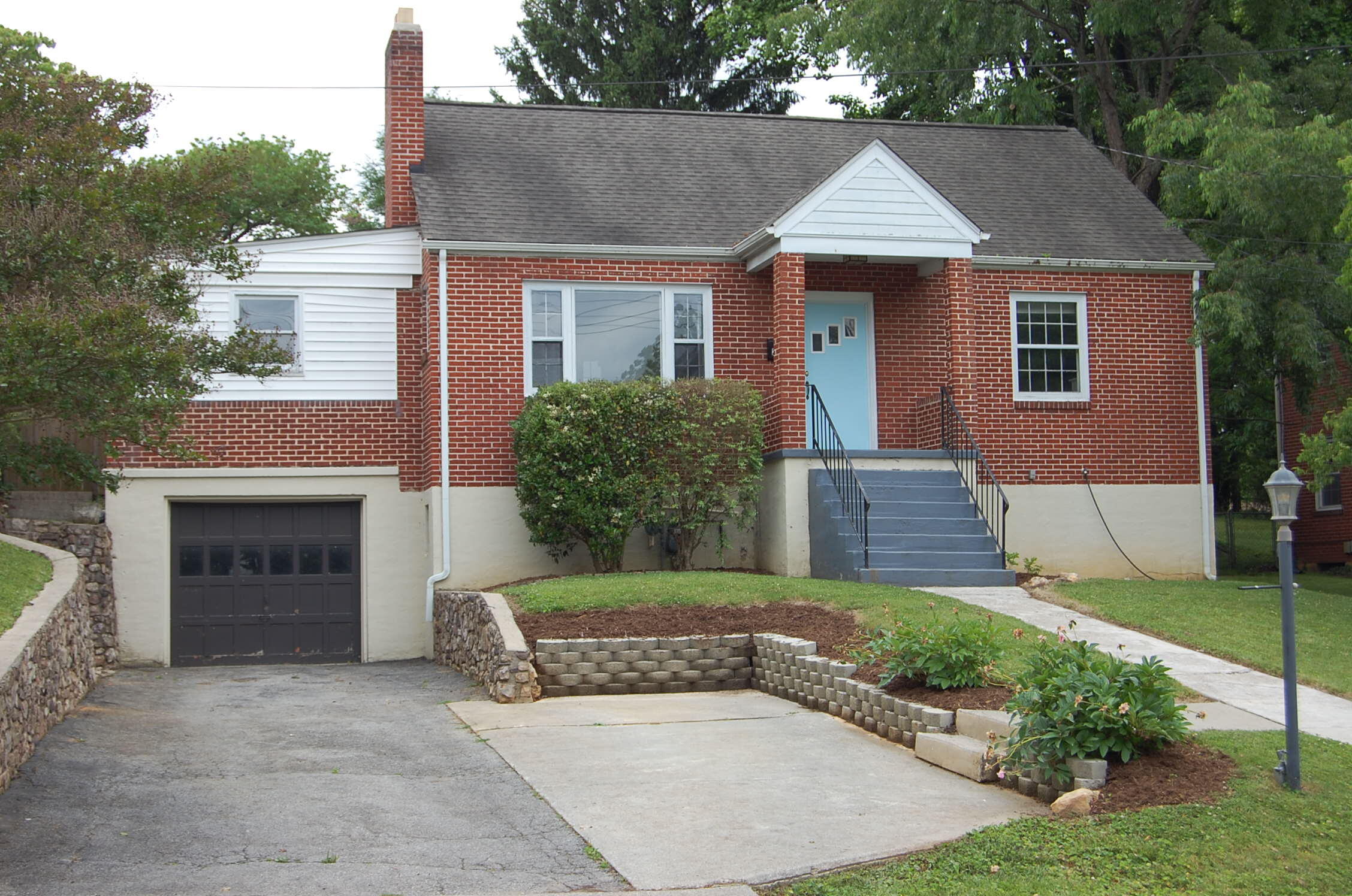 a front view of a house with a garden and plants