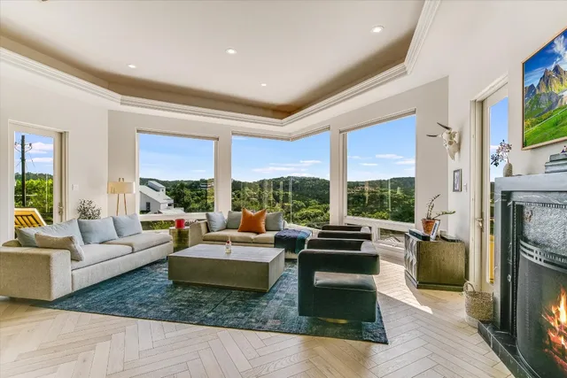 a living room with furniture large windows and a fireplace