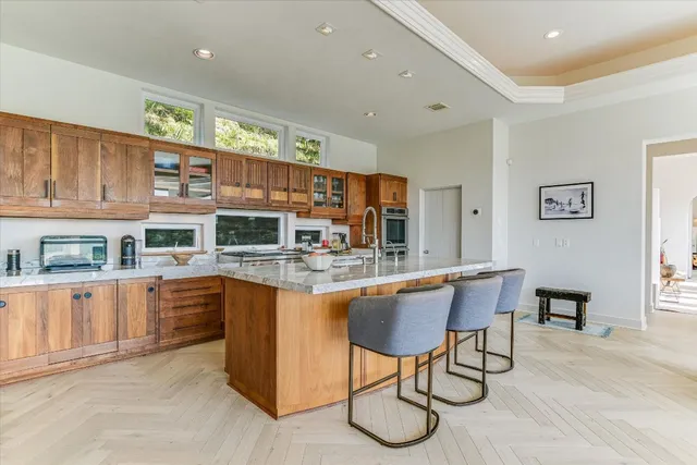 a kitchen with stainless steel appliances granite countertop table chairs and wooden cabinets