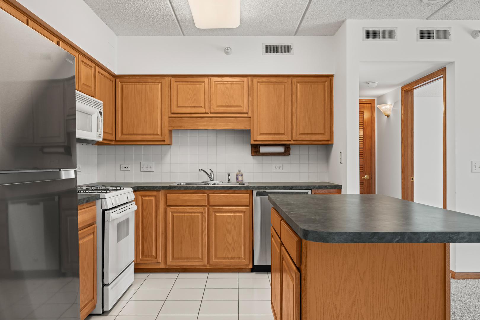 750 Pearson Street, Unit 812 Des Plaines, IL 60016 - Photo 3 of 15 a kitchen with stainless steel appliances granite countertop a sink stove and cabinets