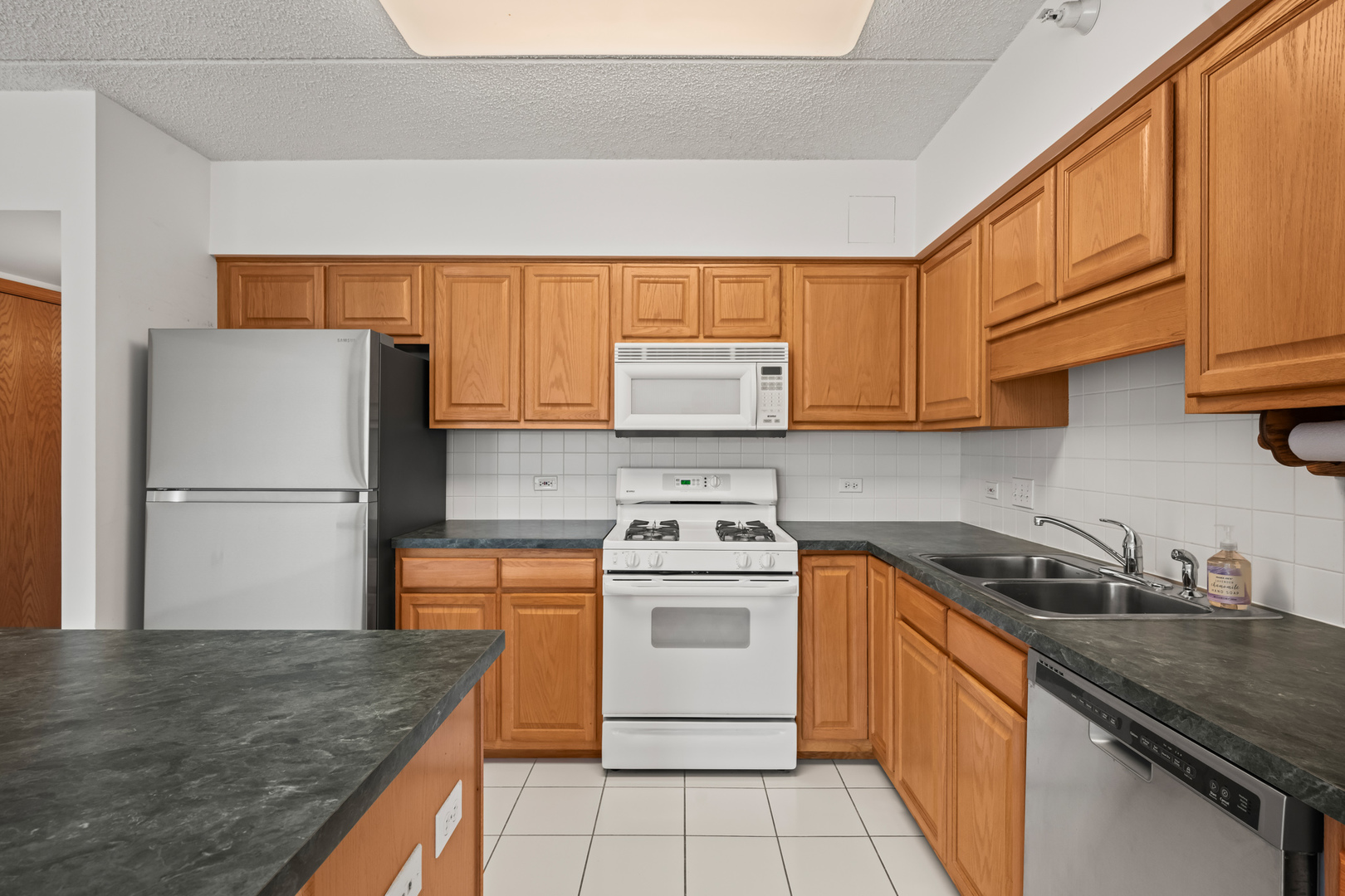 750 Pearson Street, Unit 812 Des Plaines, IL 60016 - Photo 4 of 15 a kitchen with a sink a stove and refrigerator