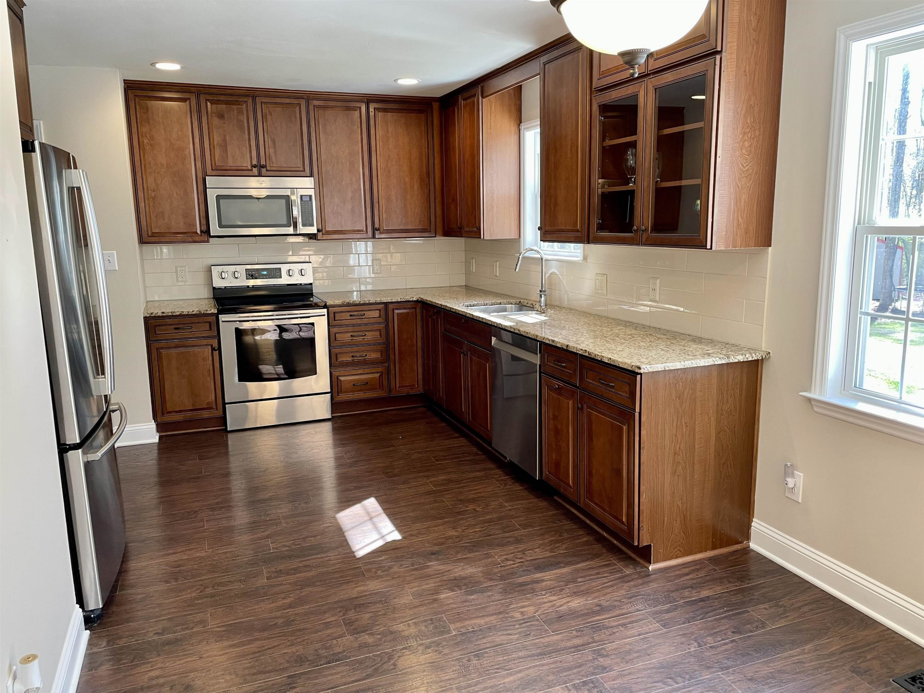 128 Deerview Drive Willow Spring, NC 27592 - Photo 11 of 34 a kitchen with stainless steel appliances granite countertop a refrigerator a sink dishwasher a stove and a oven with wooden floor
