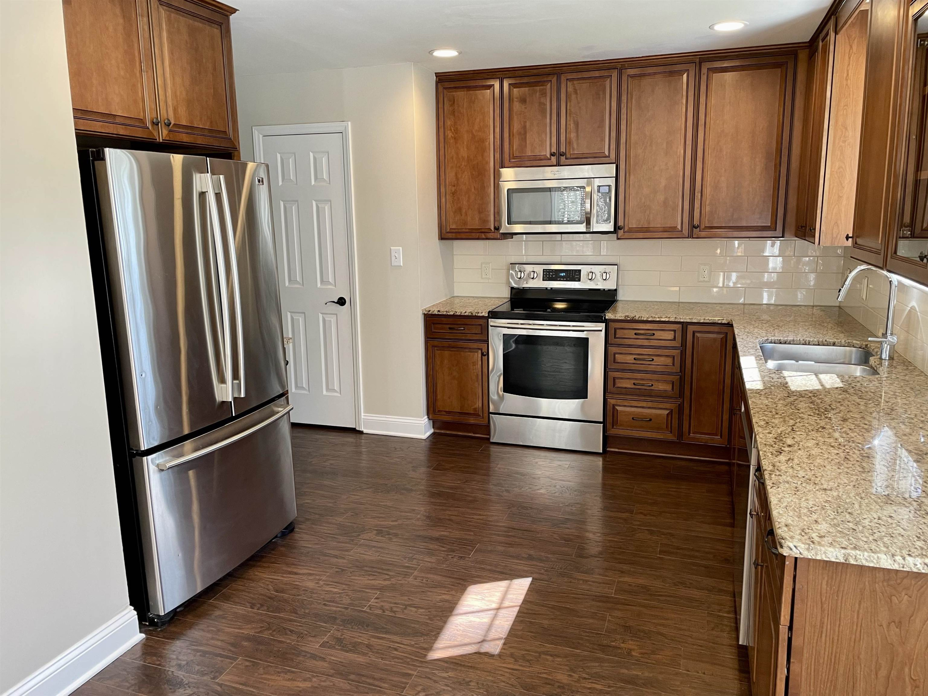 128 Deerview Drive Willow Spring, NC 27592 - Photo 12 of 34 a kitchen with granite countertop stainless steel appliances and wooden cabinets