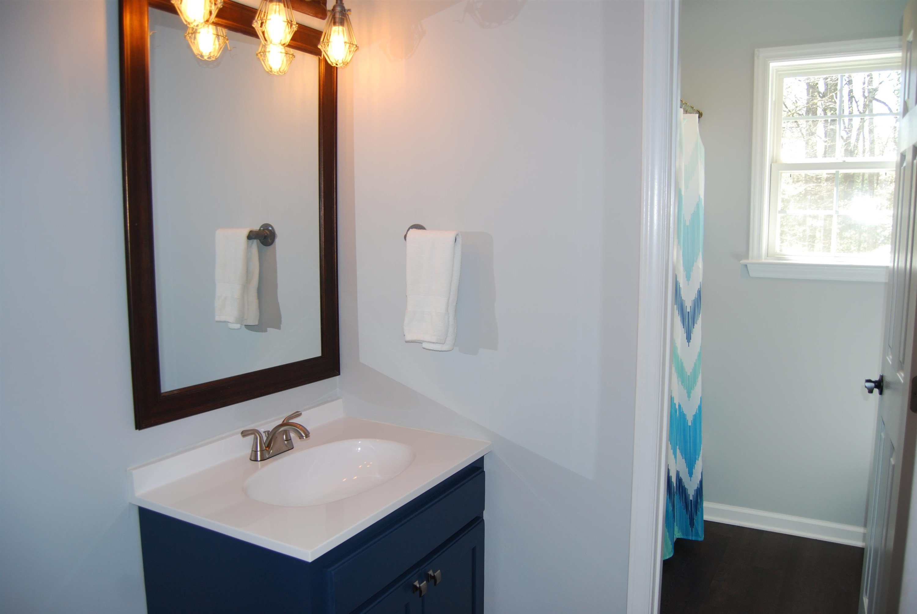 128 Deerview Drive Willow Spring, NC 27592 - Photo 27 of 34 a bathroom with a sink and a mirror
