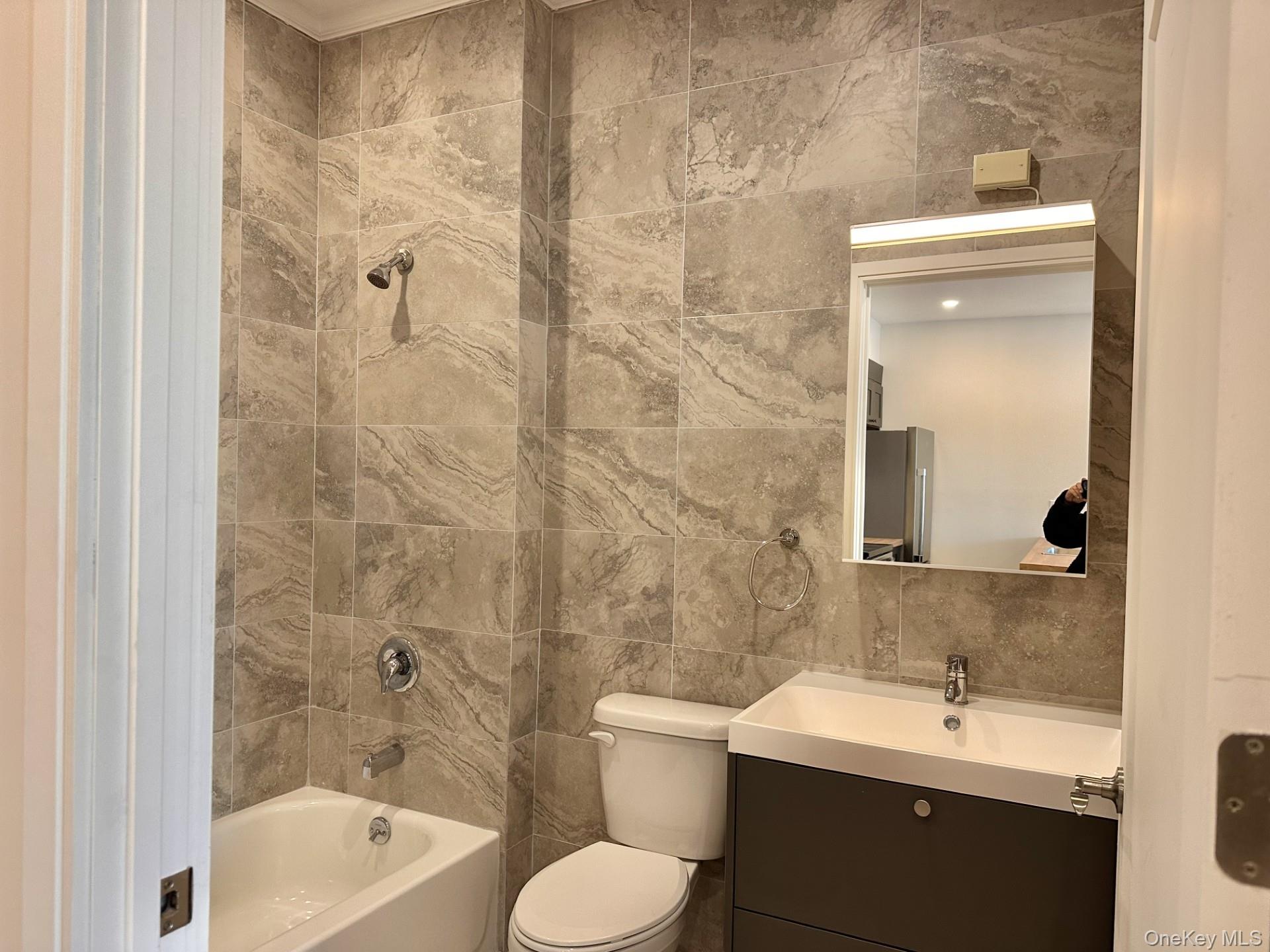 362 West Merrick Road, Unit 201 Valley Stream, NY 11580 - Photo 5 of 6 Full bath featuring tile walls, vanity, and bathing tub / shower combination